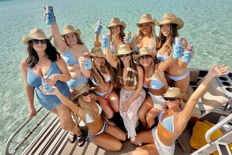 bachelorette party holding drinks on double decker pontoon boat at crab island in destin fl