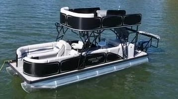 double decker pontoon with a slide and trampoline floating in the water in destin florida