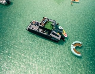arial view of a pontoon boat with a floating water couch connected to the boat