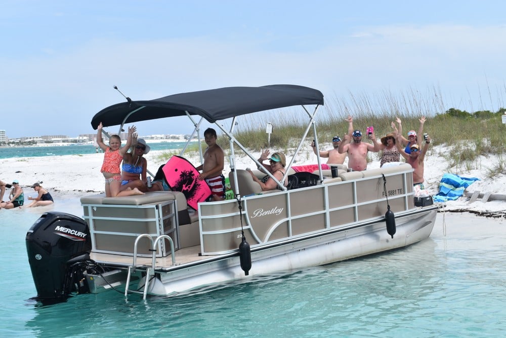 multiple people on a pontoon boat that is beached in destin, florida
