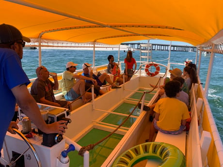 passengers enjoying a shuttle boat ride on a glass bottom tour boat out to crab island