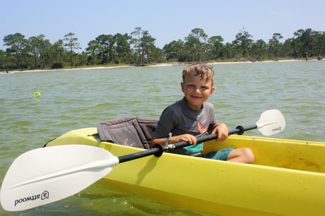boy kayaking along the okaloosa seashore 