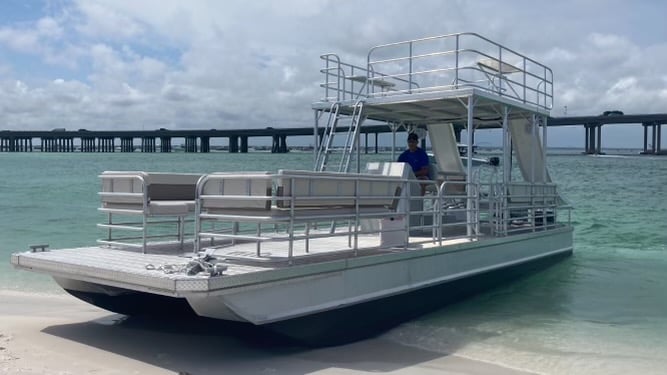 double decker pontoon boat parked on the beach at the destin harbor