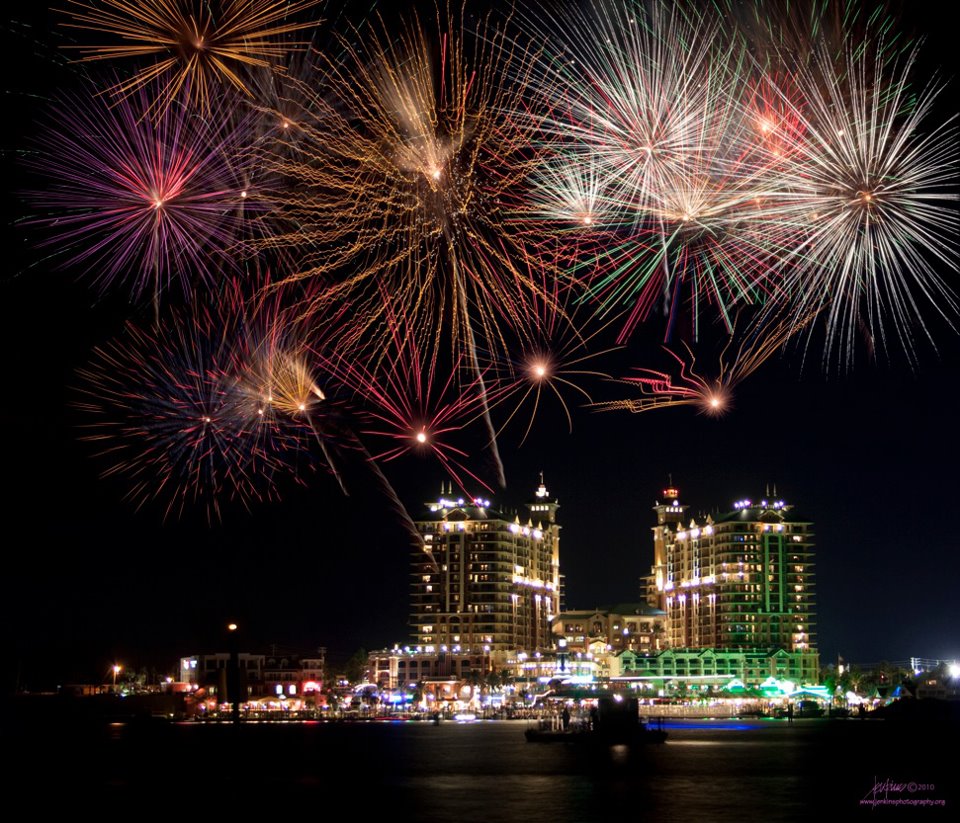 fireworks over the destin harbor with buildings lit up