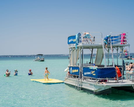 boy standing on a floating lily pad water mat at crab island in destin florida