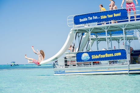 man sliding off a double decker pontoon in destin fl