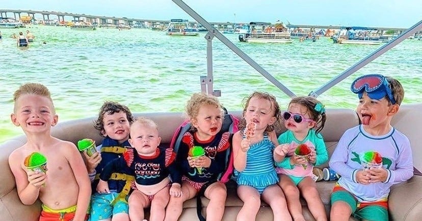 seven happy children eating snow cones on a pontoon boat in destin, florida