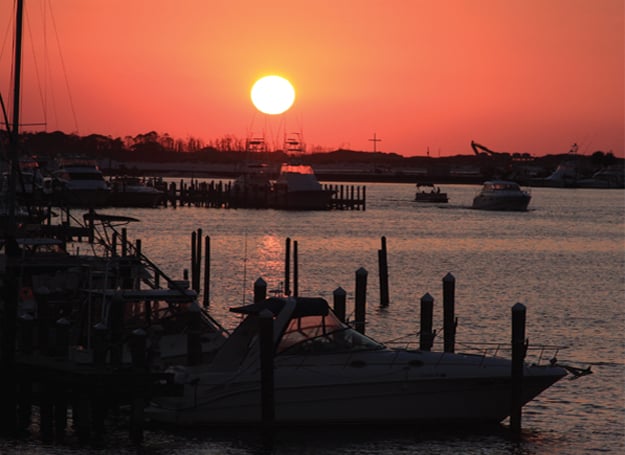 sunset of the destin harbor with boats in it