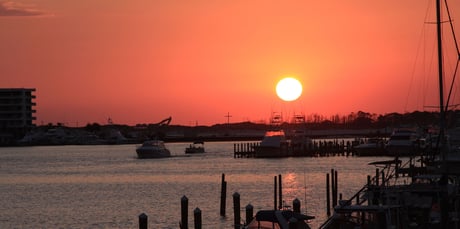 sun setting over the destin harbor in october