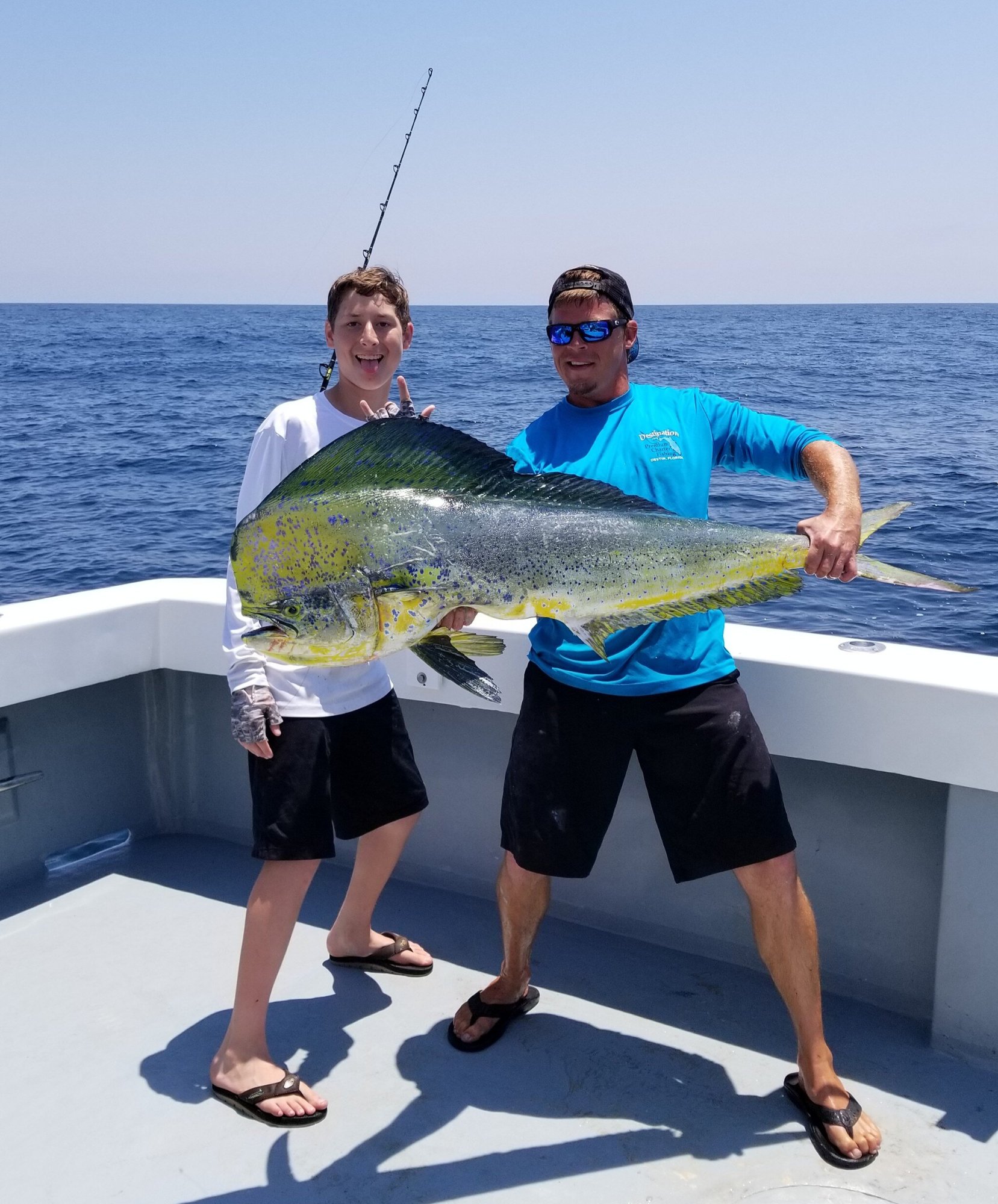 two men holding a mahi mahi fish on a charter boat in the gulf of mexico