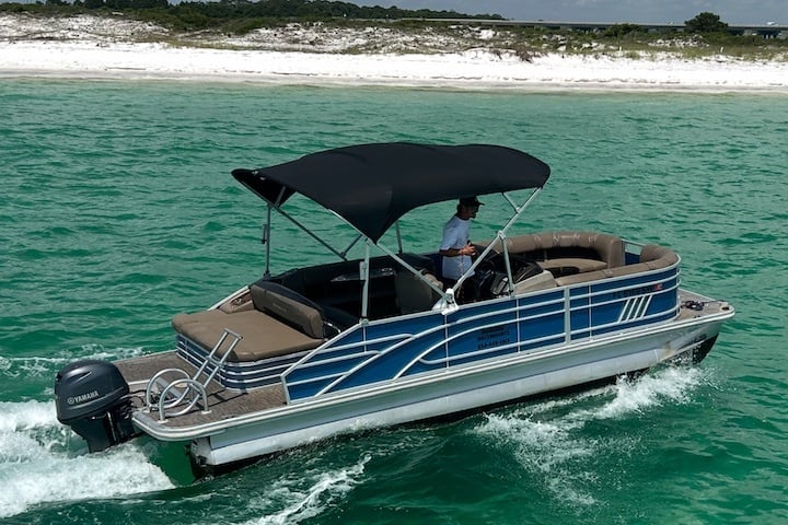 man cruising through the destin harbor on pontoon boat in destin florida
