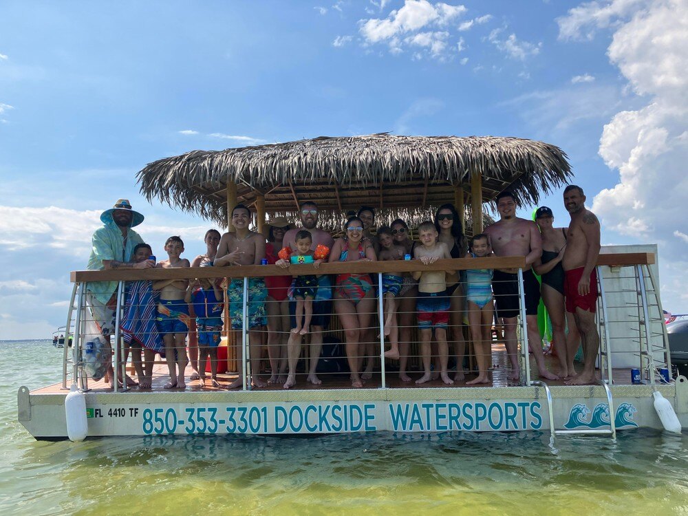 lots of people having fun on a tiki boat at crab island