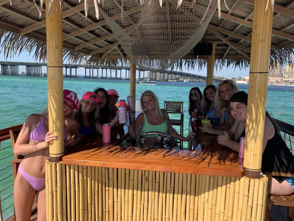nine girls celebrating on a tiki boat in crab island