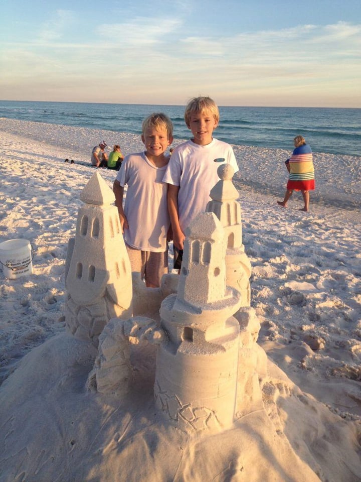 kids making a sand castle on the beach