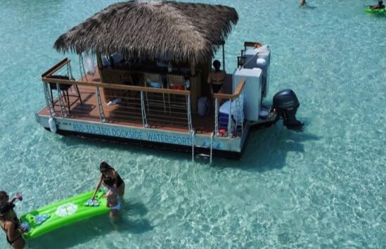 family hanging out on a floating tiki boat at crab island in destin florida